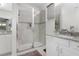 Bright bathroom featuring white cabinets, granite countertops and a glass shower with updated fixtures at 14602 Winter Stay Dr, Winter Garden, FL 34787