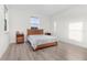 Bright, spacious bedroom with wood laminate floors, a window, and a comfortable queen size bed at 14602 Winter Stay Dr, Winter Garden, FL 34787