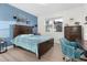 A bright bedroom features a blue accent wall, modern furniture and updated flooring at 14602 Winter Stay Dr, Winter Garden, FL 34787