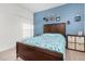 A bright bedroom featuring a blue accent wall, modern furniture and luxury vinyl plank flooring at 14602 Winter Stay Dr, Winter Garden, FL 34787