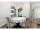 Bright dining area with a round table, modern chandelier, and large windows offering a pleasant view at 14602 Winter Stay Dr, Winter Garden, FL 34787