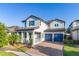 Two-story home featuring a tile roof, brick driveway, blue shutters and a two-car garage at 14602 Winter Stay Dr, Winter Garden, FL 34787