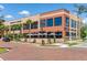 A view of a mixed use brick building with commercial businesses and palm trees at 14602 Winter Stay Dr, Winter Garden, FL 34787