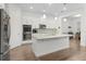 Modern, all-white kitchen featuring stainless steel appliances, granite countertops, and a large center island at 14602 Winter Stay Dr, Winter Garden, FL 34787