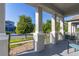 View of the front porch, showcasing gray columns, brick-lined walkway, and a peek into the home's vibrant neighborhood at 14602 Winter Stay Dr, Winter Garden, FL 34787
