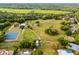 Spacious aerial view featuring tennis courts, equestrian facilities, and sprawling green fields, perfect for recreation at 1475 Warrior Trl, Enterprise, FL 32725