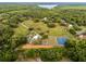 Aerial view showcasing tennis courts and equestrian facilities amongst lush greenery, offering recreational opportunities at 1475 Warrior Trl, Enterprise, FL 32725