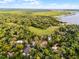 Aerial view of property highlighting mature trees, lush greenery, and a serene pond surrounded by residential homes at 1475 Warrior Trl, Enterprise, FL 32725