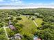Aerial view of a sprawling property featuring lush green fields and tree-lined landscape near a body of water at 1475 Warrior Trl, Enterprise, FL 32725