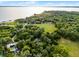 Panoramic aerial view showing lakefront property surrounded by lush greenery and mature trees at 1475 Warrior Trl, Enterprise, FL 32725