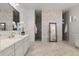 This bathroom boasts dual sinks, walk-in shower, and modern finishes at 1475 Warrior Trl, Enterprise, FL 32725