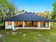 Rear exterior of the house showcasing its spacious screened-in patio and natural surroundings at 1475 Warrior Trl, Enterprise, FL 32725