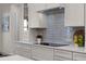Modern kitchen with sleek countertops, gray backsplash, and stylish appliances at 1475 Warrior Trl, Enterprise, FL 32725