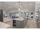 Open kitchen with a large island, stainless steel appliances, and a view into the living room at 1475 Warrior Trl, Enterprise, FL 32725