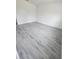 Spacious room featuring gray wood-look flooring and a door to an adjacent room at 15462 Sw 46 Cir, Ocala, FL 34473