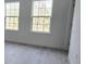 A bedroom featuring two windows and light-colored laminate flooring at 15462 Sw 46 Cir, Ocala, FL 34473