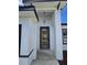 A modern front door design with clear glass and a sleek, dark frame against a stucco wall at 15462 Sw 46 Cir, Ocala, FL 34473