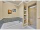 Stylish bathroom with soaking tub, tiled shower, and decorative shelving at 1741 Pine Ave, Winter Park, FL 32789