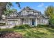 Charming two-story home with stone accents, a well-manicured lawn, and a bright blue front door at 1741 Pine Ave, Winter Park, FL 32789