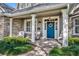 Inviting covered porch with stone accents, decorative columns, and cozy seating area with a blue front door at 1741 Pine Ave, Winter Park, FL 32789