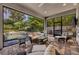 Inviting screened patio featuring wicker furniture, stone floors, and a lovely view of the pool at 1741 Pine Ave, Winter Park, FL 32789