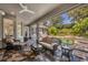 Inviting screened patio with stone floors, ceiling fan, and wicker furniture overlooking a beautiful pool at 1741 Pine Ave, Winter Park, FL 32789