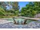 Relaxing pool area with stone accents, lush landscaping, and cozy lounge chairs for serene enjoyment at 1741 Pine Ave, Winter Park, FL 32789