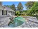 Relaxing pool area with stone accents, lush landscaping, and lounge chairs for serene enjoyment at 1741 Pine Ave, Winter Park, FL 32789