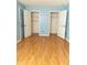 Bedroom featuring light blue walls, wood flooring and two closets with open doors at 1770 Nordic Ct, Apopka, FL 32712
