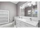 Modern bathroom featuring dual sinks, ample lighting, and decorative marble tile in the walk-in shower at 1900 Garvin St, Orlando, FL 32803