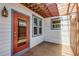 Back patio with stained concrete, string lights, and a dark-red storm door at 1900 Garvin St, Orlando, FL 32803