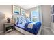 Bright bedroom with coastal decor, blue bedding, and natural light from a window with blue patterned curtains at 1944 Tamarack Pass, Davenport, FL 33837