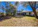 Back exterior showing a screen-enclosed pool, manicured lawn, mature trees, and a charming wooden fence along the perimeter at 20773 Starry St, Orlando, FL 32833