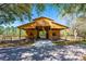 Exterior shot of a newly constructed barn with covered parking, set amidst trees and fencing on a sunny day at 20773 Starry St, Orlando, FL 32833
