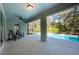 A covered patio looks out onto a screened-in swimming pool surrounded by lush greenery at 20773 Starry St, Orlando, FL 32833
