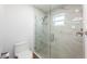 Modern glass-enclosed shower with rainfall showerhead, neutral tile, and pebble floor at 20773 Starry St, Orlando, FL 32833