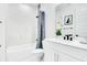 Bright bathroom featuring a white tub, white cabinets, black hardware, and a shower with decorative tile at 2348 Victoria Dr, Davenport, FL 33837