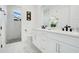 Bright bathroom featuring double sinks with black hardware, white cabinets, a tile shower and tile flooring at 2348 Victoria Dr, Davenport, FL 33837