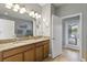 Bathroom featuring a double vanity, decorative mirrors, and access to the screened pool area at 2371 Victoria Dr, Davenport, FL 33837