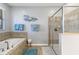 Bright bathroom with a soaking tub, glass shower, and decorative fish accents at 2371 Victoria Dr, Davenport, FL 33837