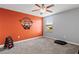 Bright bedroom with a bold orange accent wall, window, and weight set at 2371 Victoria Dr, Davenport, FL 33837