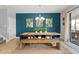 Stylish dining room with blue accent wall, wood table, bench seating, and access to the outdoor area at 2371 Victoria Dr, Davenport, FL 33837