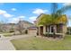 Attractive home with two-car garage, brick driveway, stone accents, and a well-maintained lawn at 2371 Victoria Dr, Davenport, FL 33837