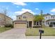 Beautiful two-story home featuring a brick driveway, attached two-car garage, and meticulously maintained landscaping at 2371 Victoria Dr, Davenport, FL 33837