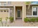 Inviting entryway featuring a stone facade, dark green front door, and well-manicured shrubbery at 2371 Victoria Dr, Davenport, FL 33837