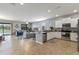 Open-concept kitchen featuring stainless steel appliances, white cabinetry, and an eat-in bar area at 2371 Victoria Dr, Davenport, FL 33837