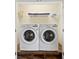 Convenient laundry room featuring modern, white front-load washer and dryer on a wood platform at 2371 Victoria Dr, Davenport, FL 33837