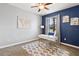Stylish office with blue accent wall, modern desk, ceiling fan, and ample natural light at 2371 Victoria Dr, Davenport, FL 33837