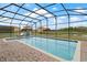 Beautiful screened-in pool with open backyard and relaxing views of green space and a pond at 2371 Victoria Dr, Davenport, FL 33837