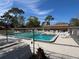 Community pool surrounded by lush landscaping and lounge chairs under a clear blue sky at 250 Raintree Dr, Casselberry, FL 32707